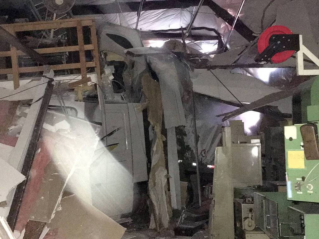 Driver hospitalized after crashing semi into building