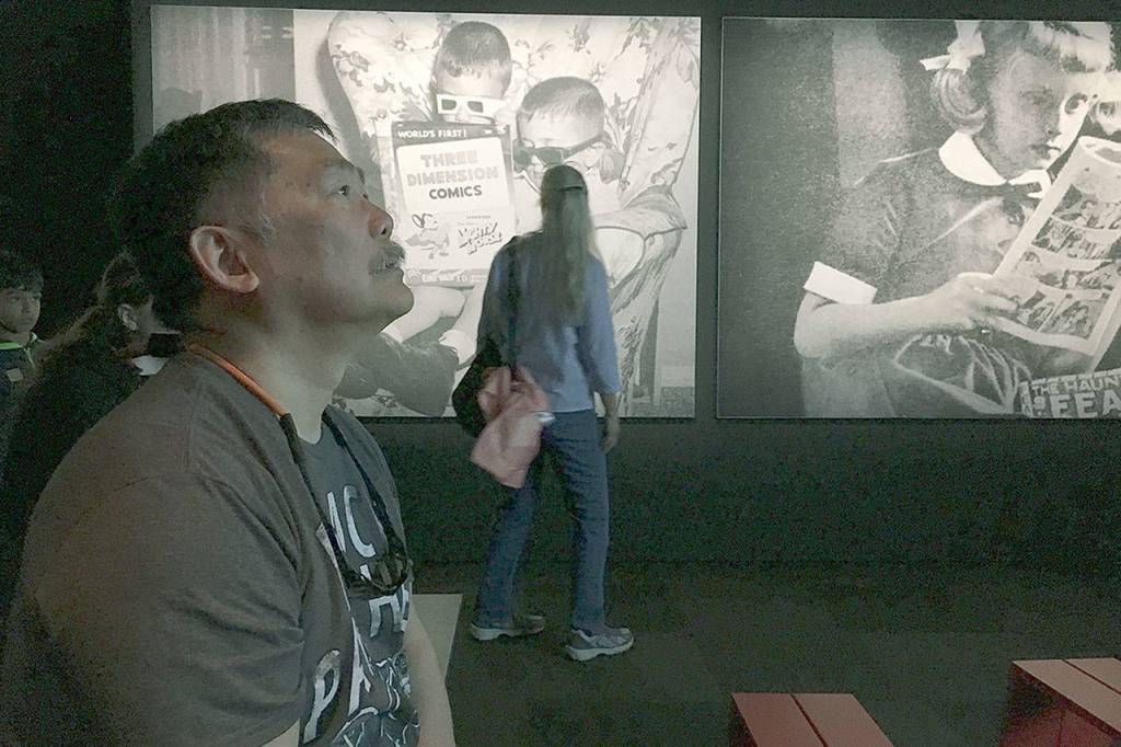 Glen Watanabe watches an introductory video detailing some of Marvel Comics history in the special exhibit at the Museum of Pop Culture, aka MoPOP. (Ben Watanabe / The Herald)