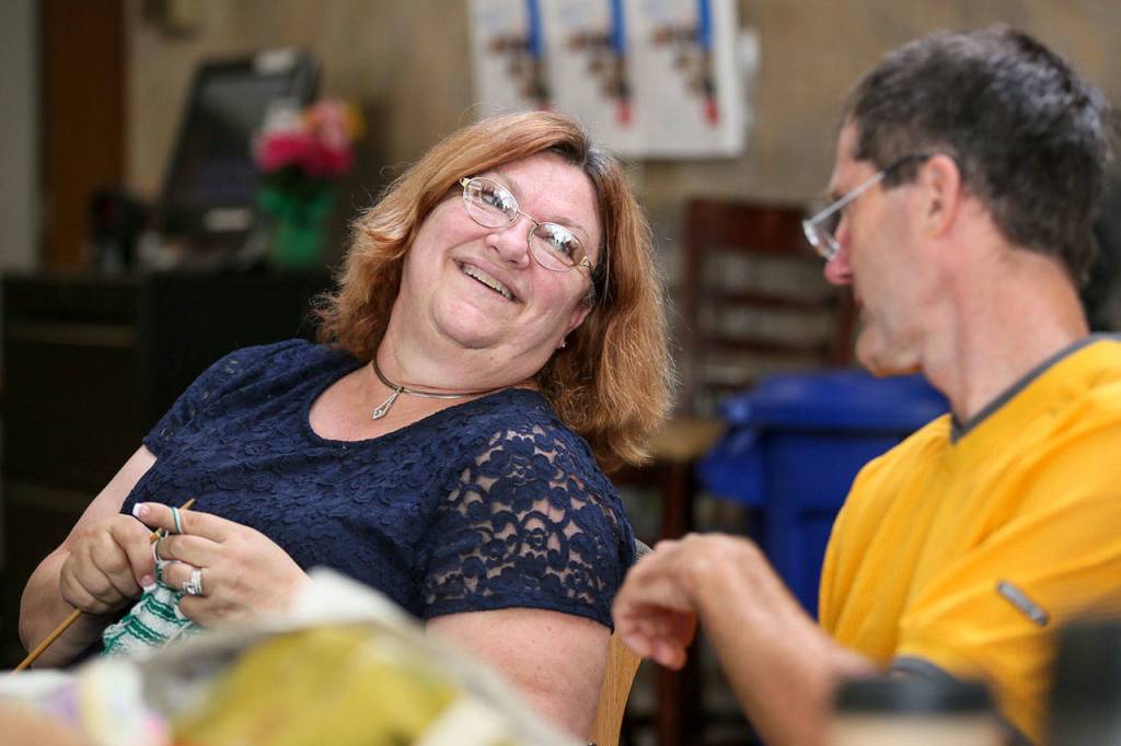 Cathy Currie (left) shares a laugh with Bob Seaman during the weekly meet up of the Knit Wits and Happy Hookers at the Carl Gipson Senior Center Thursday afternoon in Everett on July 26, 2018. (Kevin Clark / The Herald)