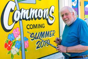 Professional sign painter Mack Benek puts the finishing touches on the windows of an Edmonds building undergoing a transformation. The owner wanted the building to look good while it was empty. Benek, 72, has hand-lettered many signs on windows and businesses in Edmonds and Seattle. (Bob Sears)