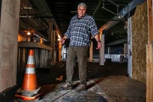 Chandler Williamson, a board member of the Everett Recovery Cafe, points out that some work that needs to be done to the lower level of the old Everett Public Market before it can become the cafes new home. (Dan Bates / The Herald)