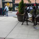 Dan DeMascio (left) and Robert Alkire move the Live Your Song piano to its place in front of Major League Pizza in Everett on Aug. 1. (Olivia Vanni / The Herald)