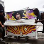 Brian Walsh (left) and Alton Johnson of Piano and Organ Moving Co. Inc. move the Jimi Hendrix Experience piano into their moving van on Aug. 1. (Olivia Vanni / The Herald)