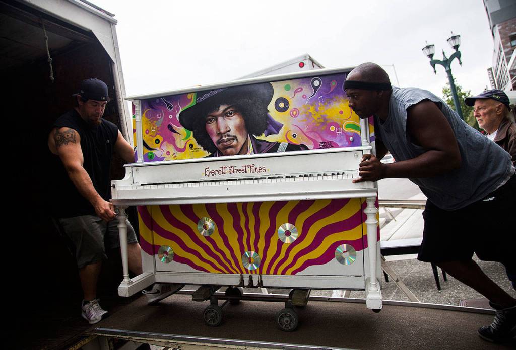 Brian Walsh (left) and Alton Johnson of Piano and Organ Moving Co. Inc. move the Jimi Hendrix Experience piano into their moving van on Aug. 1. (Olivia Vanni / The Herald)