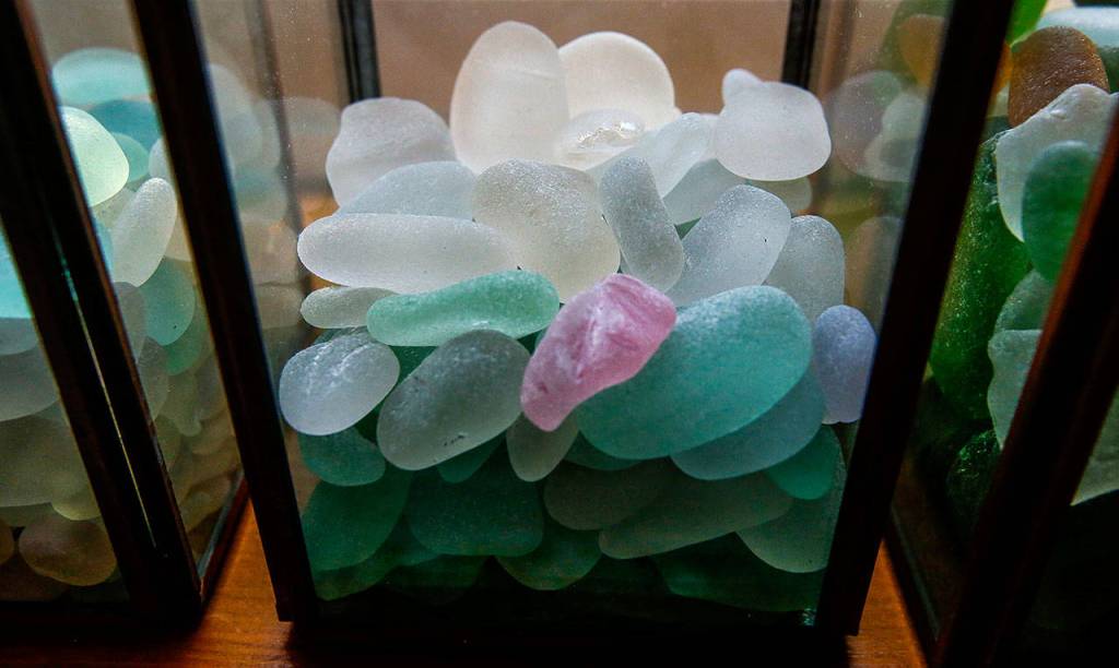 A pink piece of seaglass is given a prominent spot among the other colors of seaglass in a glass container on the window sill of Smiths special room. On a different day, however, it may be off catching light in a different spot. (Dan Bates / The Herald)