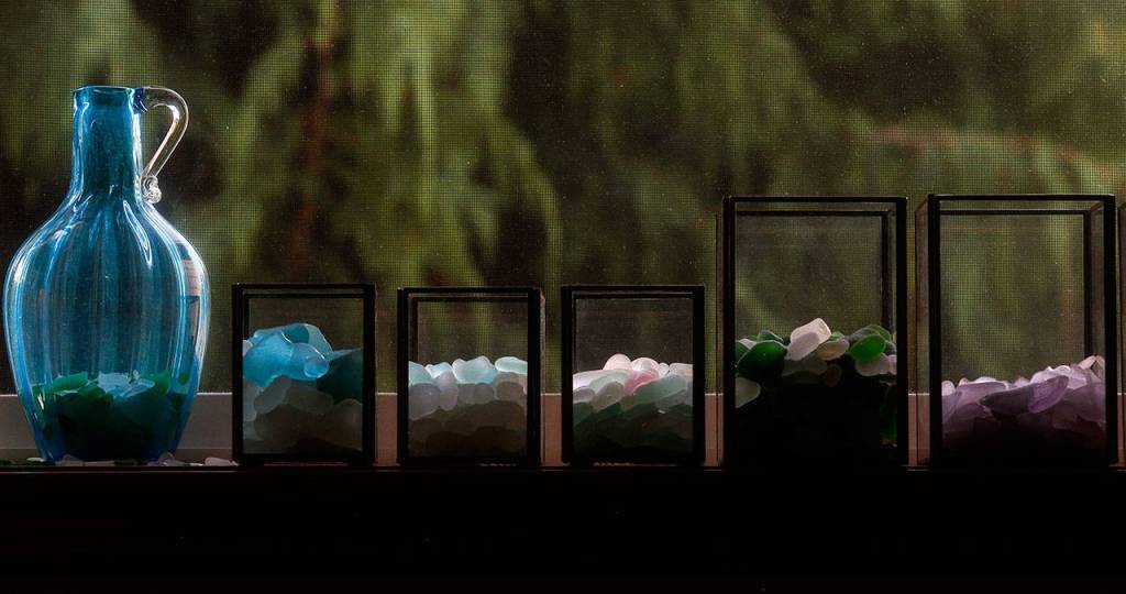 Photos by Dan Bates / The Herald                                On a window sill in Linda Smiths room, seaglass is displayed in clear glass with early morning light brushing the tops.