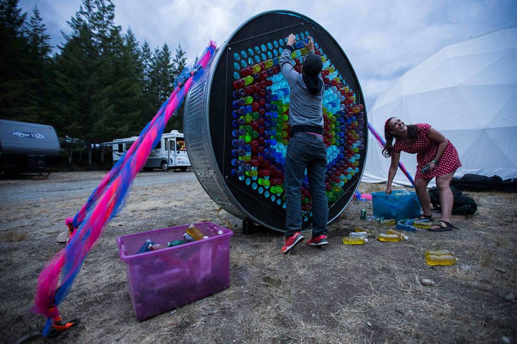 Casey Varner and Monica Conners play with a giant art installation on Thursday in Darrington. (Olivia Vanni / The Herald)