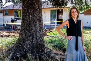 Tracy Rubstello, director of development for the Bridge Receiving Center (background), talks about the home being created as a 30-day refuge for children who are first entering foster care. (Dan Bates / The Herald)