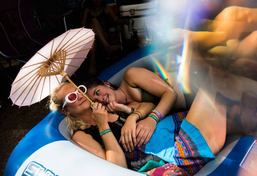 Emma Brand, left, and Ellen Goudie hangout at their campsite during the Summer Meltdown on Saturday, Aug. 4, 2018 in Darrington. (Olivia Vanni / The Herald)