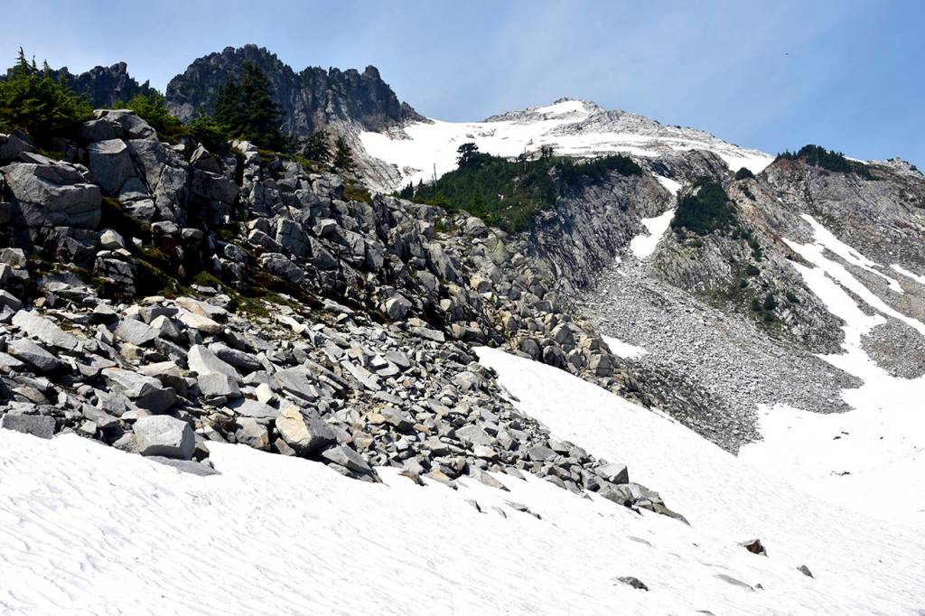 A view from the stream outlet of Vesper Lake shows snow conditions on the mountain Sunday, Aug 5, days after hiker Sam Sayers went missing. The pinnacle on the right is Vesper Peak. (Caleb Hutton / The Herald)