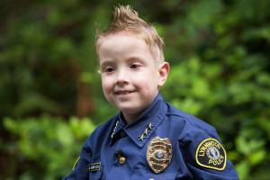 Chief for a Day Luca Keogh,7, is sworn in as chief of Lynnwood police during a city council meeting on Monday, Aug. 13, 2018 in Lynnwood, Wa. Its Lynnwoods first time doing this. Keogh has been diagnosed with spina bifida, hydrocephalus, slit ventricle syndrome, chiari malformation, and tethered cord syndrome. (Andy Bronson / The Herald)