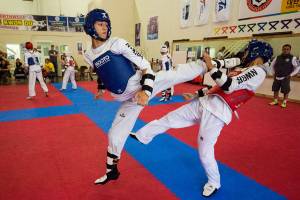 Isaak Whitworth, left, spins a kick at Sung Ho Park, 18, during sparing at NW Black Belt Taekwondo on Thursday, Aug. 9, 2018 in Lynnwood, Wa. (Andy Bronson / The Herald)