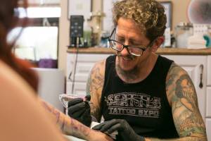 Abigail Espinoza is tattooed by Michael Gardner, of Tattoo Garden, at his shop in Everetts historic Lowell district on Aug. 8. He will be among one of three Everett artists featured at the 17th annual Seattle Tattoo Expo this weekend. (Kevin Clark / The Herald)