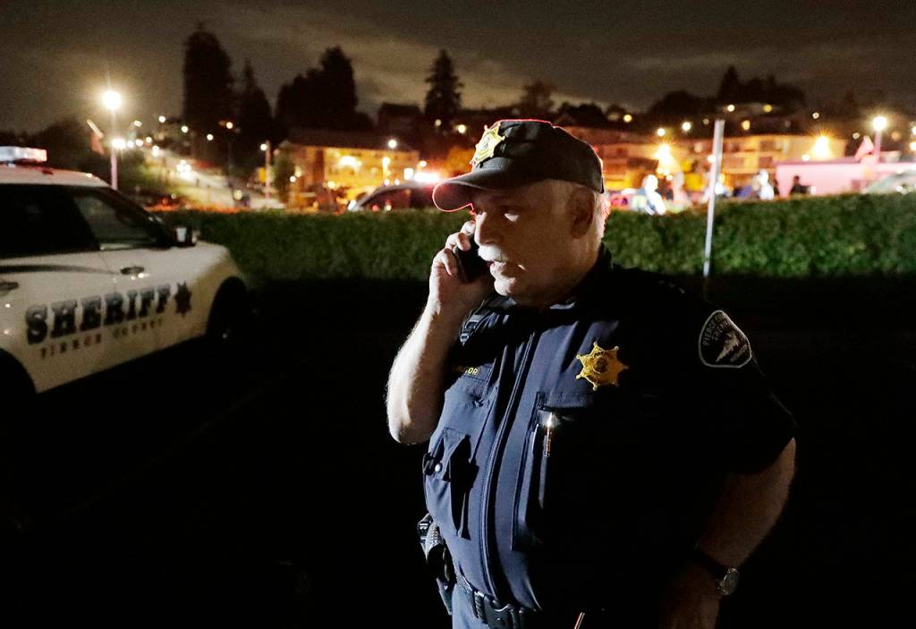 Pierce County Sheriff Paul Pastor talks on his phone at a staging area Friday at the ferry terminal in Steilacoom, near where a Coast Guard spokeswoman said the agency was responding to a report of a smoke plume and possible plane crash. (AP Photo/Ted S. Warren)