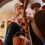 Elaine Wilson creates fine wool yarn on her spinning wheel at one end of the kitchen. (Dan Bates / The Herald)