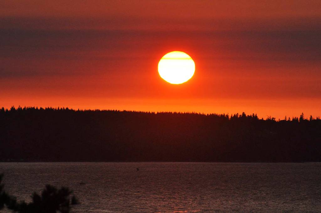 The smoky air makes for colorful sunsets, such as this one over Possession Sound on Monday evening. (Sue Misao / The Herald)