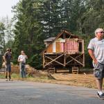 Local residents watch as a house is moved Wednesday down Bellflower Road in Bothell. (Olivia Vanni / The Herald)