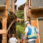 Casjen Cramer, of Nickel Bros., looks up to see how the main house lines up with the garage structure during the moving of a house Wednesday on Bellflower Road in Bothell. (Olivia Vanni / The Herald)