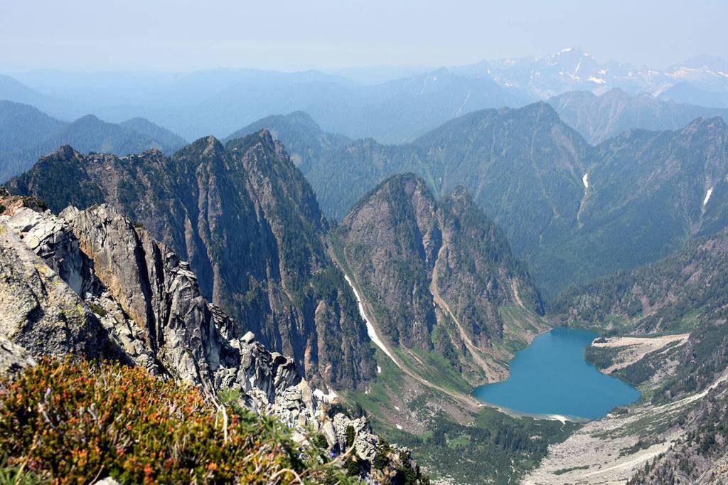 The azure-colored Copper Lake sits in a hazy bowl north of Vesper Peak, between Little Chief, at left, and Big Four Mountain, not pictured. (Caleb Hutton / The Herald)