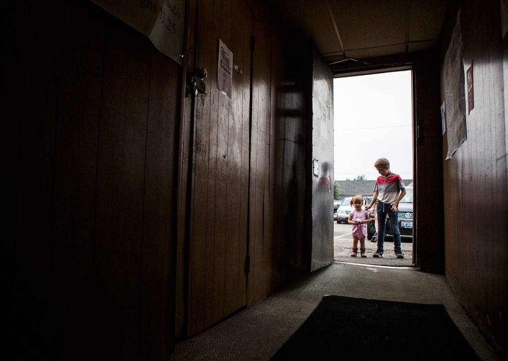 Adalynn Mitchell, 2, and brother Danny Mitchell, 11, listen to the Sauerkraut Band through the door during the Kuhnles Tavern 100th year celebration Saturday in Marysville. (Olivia Vanni / The Herald)