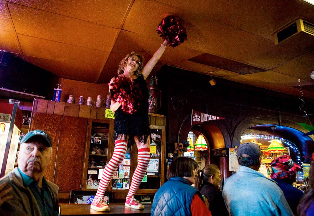 Tanya Buttke dances on the bar during the Kuhnles Tavern 100th year celebration Saturday in Marysville. (Olivia Vanni / The Herald)
