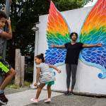 Lindsey T.H. Jackson, right, and her children, Cohen, 6, left, and Taylor, 4, center, pose for pictures in front of the butterfly wing art installation in Langley. (Olivia Vanni / The Herald)