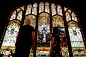 During the Everett Art Walk on Thursday, Laurie Povey Crawford (right) and Dottie Villesvik look at the large, east-facing stained-glass window with the interior lights turned down at First Presbyterian Church. The stained glass windows were created in 1910 by Povey Brothers Studio, where her great-grandfather, George Povey, worked with his brothers in Portland. (Dan Bates / The Herald)