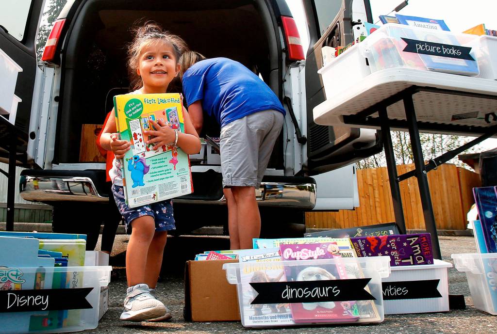 At the Snohomish Mobile Home Park, a 2-year-old named Lia is thrilled with her new Elmo & Friends book, an offering from the <a href="https://www.heraldnet.com/news/book-cafe-feeds-young-minds-at-snohomish-mobile-home-parks/" target="_blank">Book Cafe</a>. (Dan Bates / The Herald)
