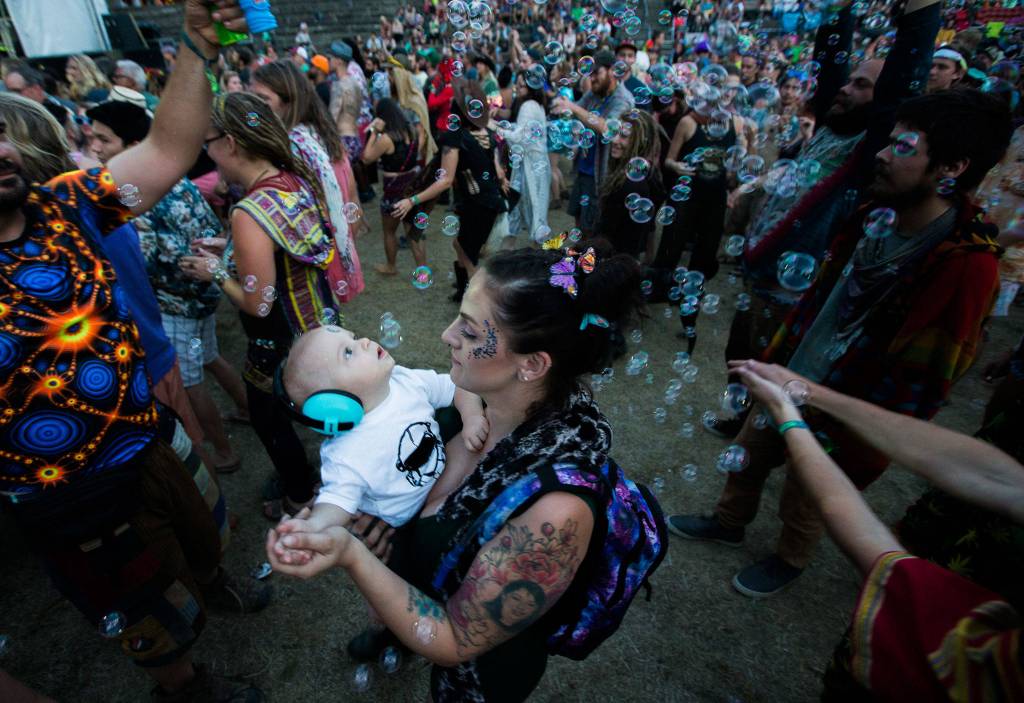 Sky Harlin, 1, looks up at bubbles being sprayed during Trevor Halls performance at the Summer Meltdown on Aug. 4, 2018 in Darrington. See a complete gallery of the Summer Meltdown <a href="https://www.heraldnet.com/life/gallery-summer-meltdown-brings-funk-and-fun-to-darrington/" target="_blank">here</a>. (Olivia Vanni / The Herald)