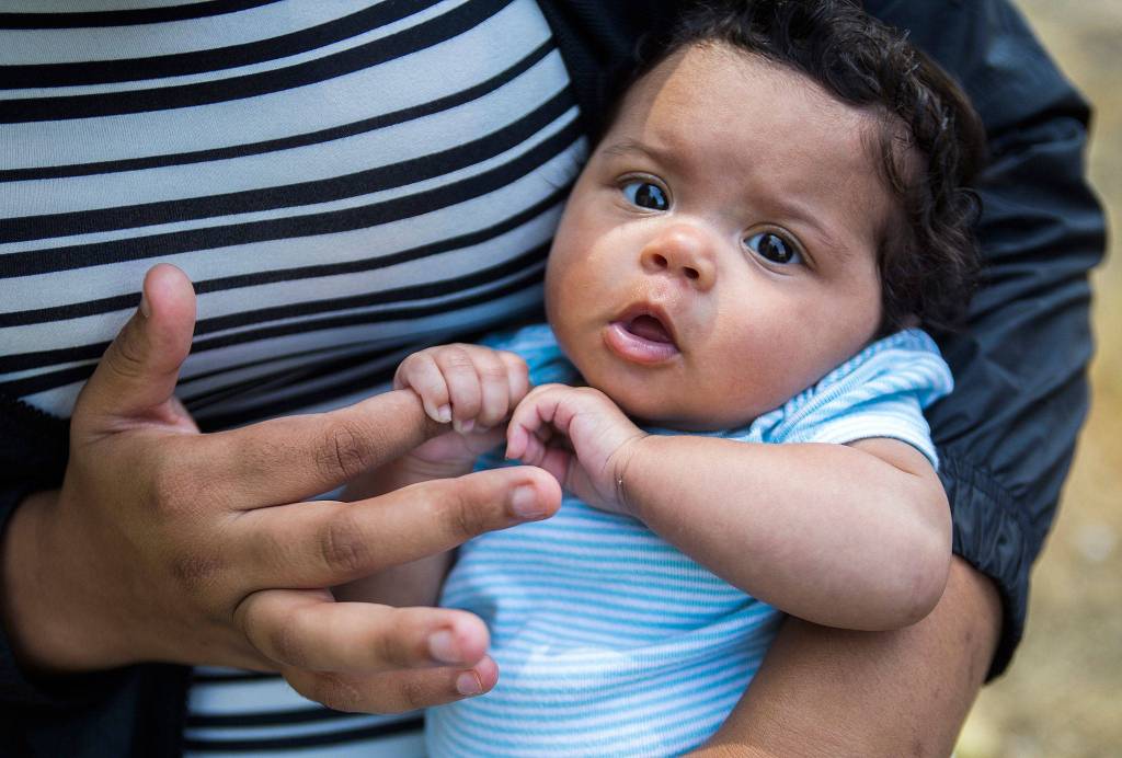 Kay Lankford, 2 months, holds onto her mothers finger at Lundeen Park on July 27, 2018, in Lake Stevens. Read about a teen moms support group <a href="https://www.heraldnet.com/news/teen-moms-lean-on-one-another-in-peer-support-program/" target="_blank">here</a>. (Olivia Vanni / The Herald)