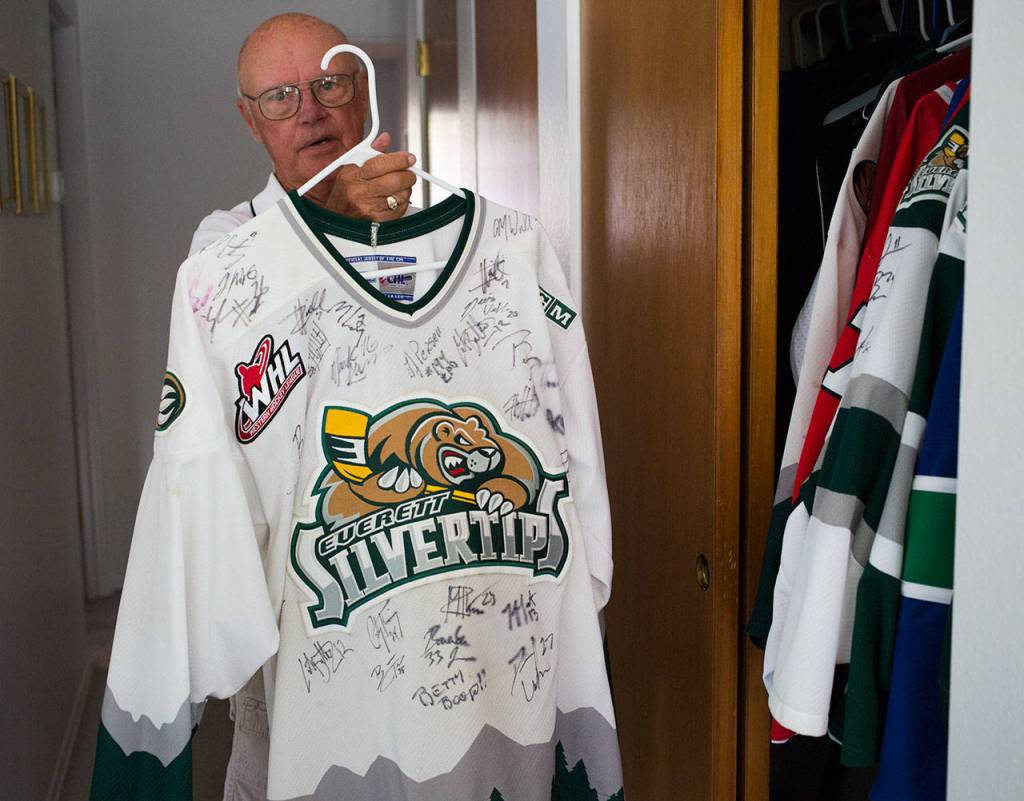 Parker Fowlds, who has been a Silvertips billet since the franchise began in 2003, holds up a team-signed jersey on Aug. 17 in his Mukilteo home. (Andy Bronson / The Herald)