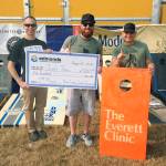 Over 50 teams competed in the second annual Beer Garden Cornhole Tournament, held Aug. 10-12 during the Taste Edmonds event. Dr. Paul Reynolds, of title sponsor The Everett Clinic, presents the first-place award to Gregs Team members Greg Cather and Mike Diaz. (Contributed photo)