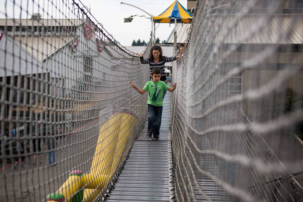 Drayden Sharpe, 5, holds onto the rope fence as he walks through an obstacle course during the Morning of Dreams at the Evergreen State Fair on Wednesday in Monroe. (Olivia Vanni / The Herald)
