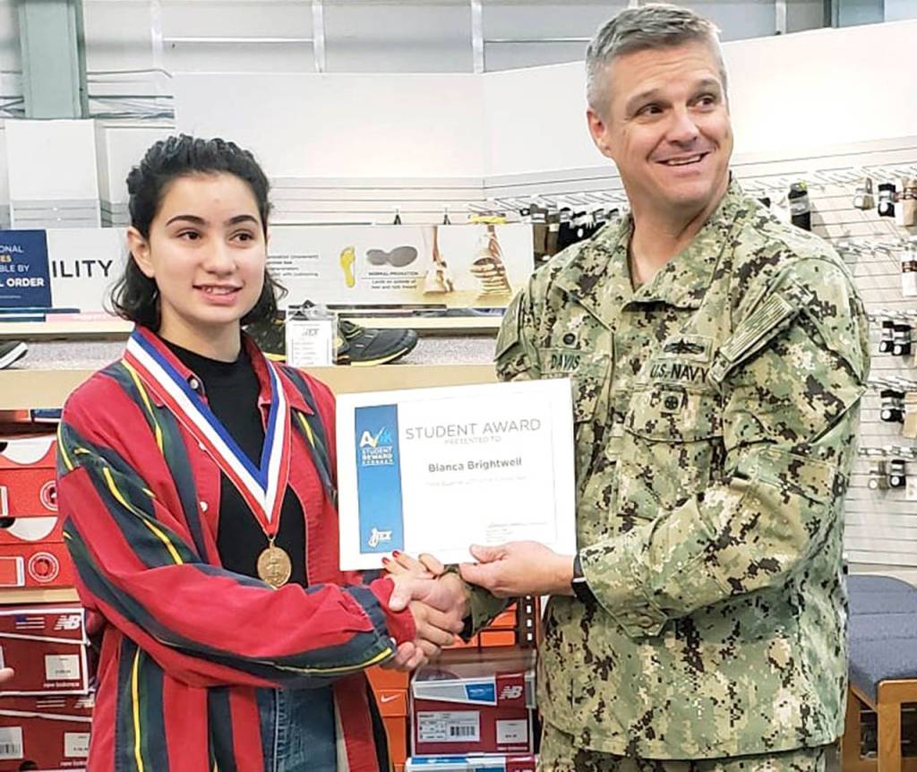 U.S. Navy Capt. Michael Davis, commanding officer of Naval Station Everett (right), congratulates Bianca Brightwell on receiving the Navy Exchanges A-OK Student Award. (Contributed photo)