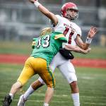 Archbishop Murphys Victor Gabalis (11) is hit as he throws by Tumwaters Jack Prentice (43) during a Class 2A state semifinal game at Sparks Stadium in Puyallup on Nov. 25, 2017. (Ian Terry / The Herald)