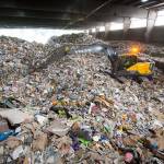 An excavator pick up recycled materials and then puts the load on a conveyor belt to be sorted and recycled at Waste Managements recycling center Tuesday in Woodinville. (Andy Bronson / The Herald)