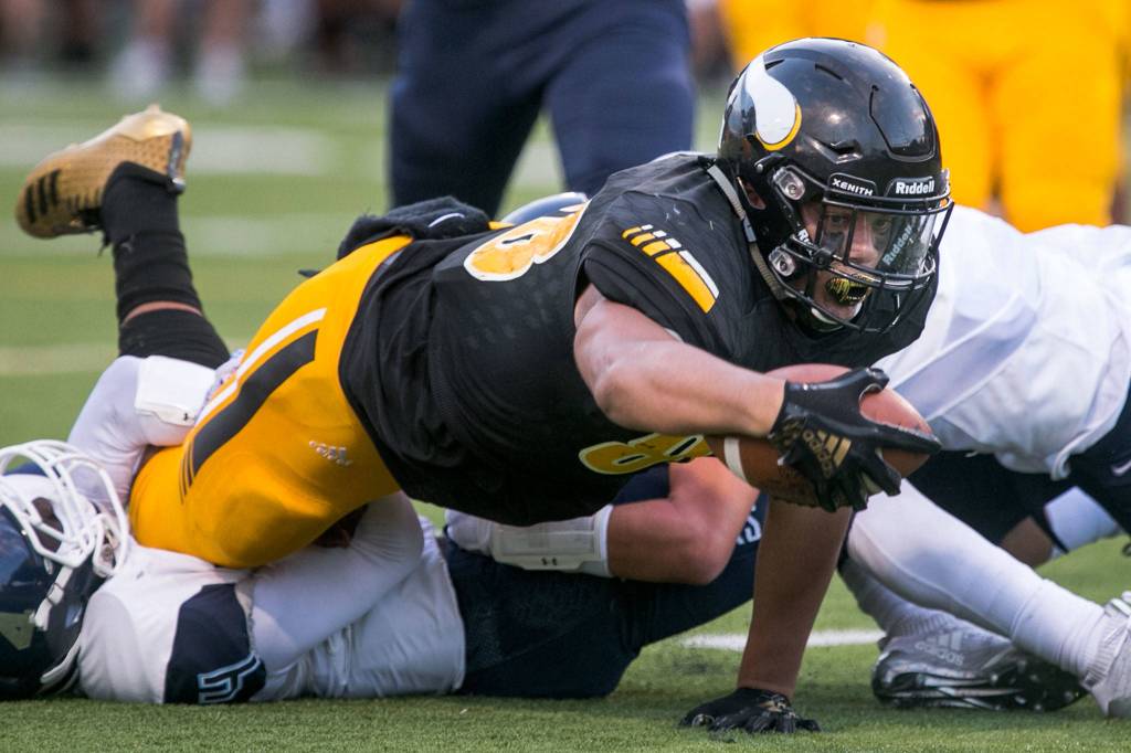 Inglemoors Quentin Moore reaches for extra yardage after a tackle Thursday night at Pop Kenney Stadium in Bothell on August 30, 2018. Inglemoor won 29-28. (Kevin Clark / The Herald)