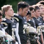 Lynnwood players stand for the national anthem with Lynnwoods Matthew Pontoh (center) decorated with a deceased teammates number before a game against Nathan Hale Aug. 31, 2018, at Edmonds Stadium. (Kevin Clark / The Herald)