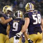 Washington running back Myles Gaskin (9) is greeted by offensive linemen Andrew Kirkland (left) and Kaleb McGary after scoring a touchdown against Washington State onNov. 25, 2017, in Seattle. (AP Photo/Ted S. Warren)