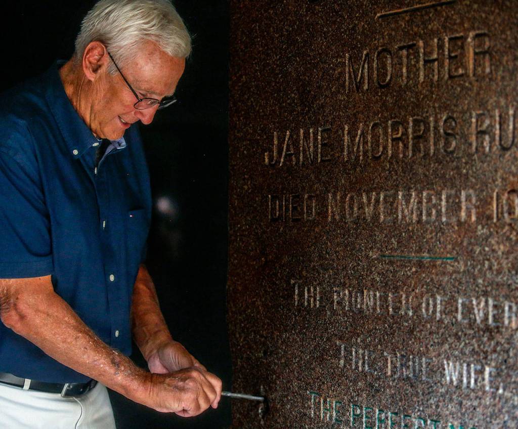 Bill Rucker tries out the vintage skeleton key in the big granite slab door of the tomb. Nobody but a cemetery worker actually keeps the key. (Dan Bates / The Herald)