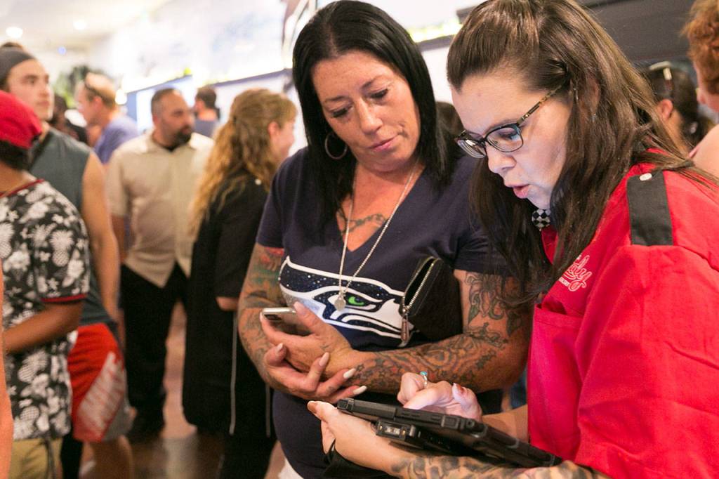 Ramie Faust (left) is checked out by Jeni Birmingham at Tulalip Remedy. (Kevin Clark / The Herald)