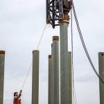 Two workers align the pile driver the pile during construction at the Port of Everett on Aug. 17, 2018 in Everett, Wa. (Olivia Vanni / The Herald)