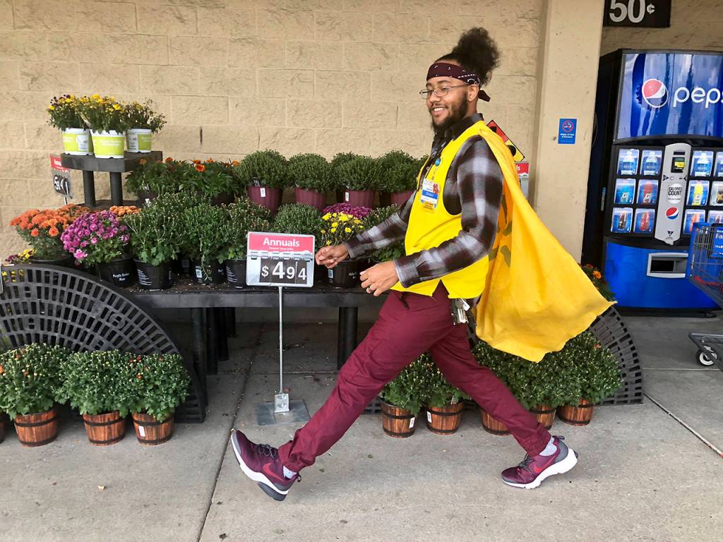 Isaiah Owens strolls past some plants at Walmart in his cape. Shoppers call him Captain Walmart, SuperWalmartman and other superhero names. (Andrea Brown / The Herald)