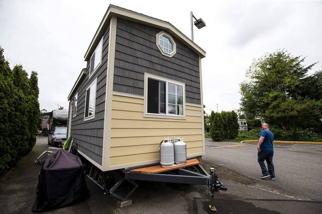 Michael Miller, the executive chef at a retirement home, admires his tiny house in Everett. It sits on a utility trailer.. (Andy Bronson / The Herald)