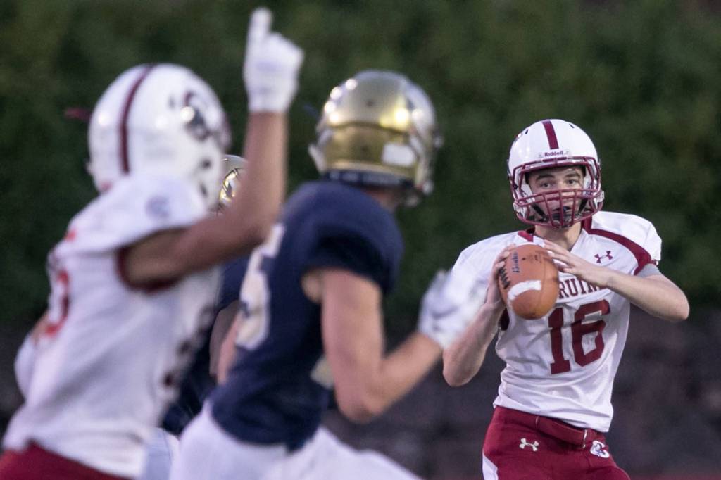 Cascades Noah Schmid (right) looks down field for pass Friday night at Everett Memorial Stadium in Everett on August 31, 2018. Cascade won 32-22. (Kevin Clark / The Herald)