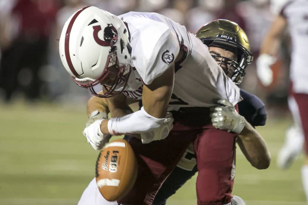 Everetts Christian Balmer forces a fumble by Cascades Davanta Murphy-Mcmillan for a touchback Friday night at Everett Memorial Stadium in Everett on August 31, 2018. Cascade won 32-22. (Kevin Clark / The Herald)