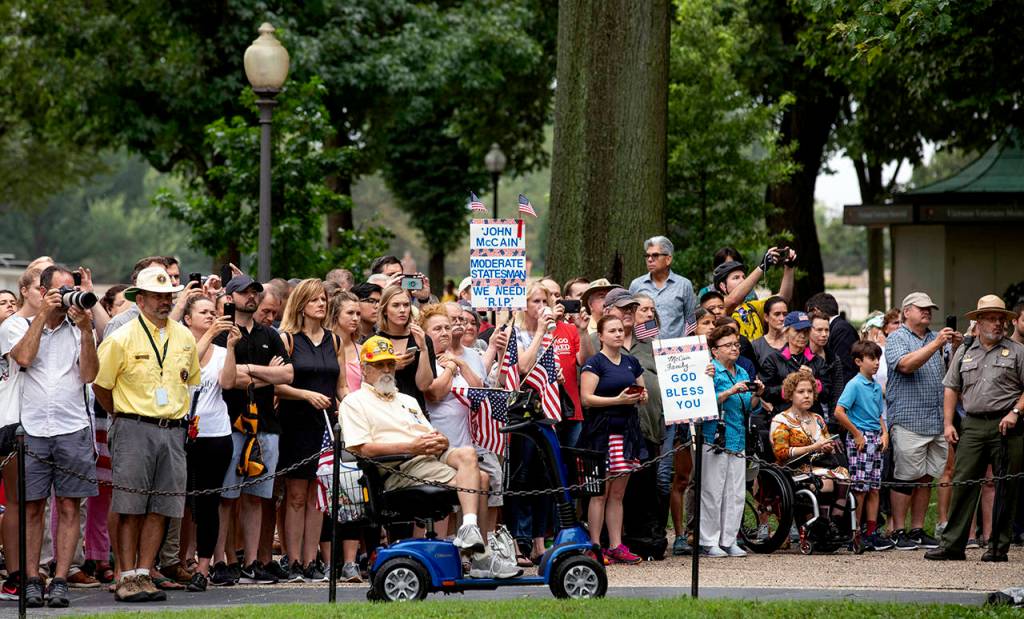 People react as Cindy McCain, the wife of Sen. John McCain, departs the Vietnam Veterans Memorial in Washington, after placing a wreath on Saturday. (Ray Whitehouse/Pool photo via AP)