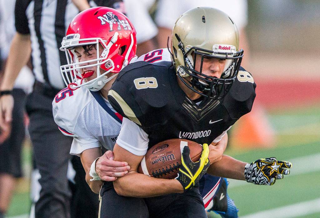 Lynnwoods Tanner Fahey is tackled by Nathan Hales Chris Coon during Fridays game against Nathan Hale on Aug. 31, 2018 in Edmonds, Wa. (Olivia Vanni / The Herald)