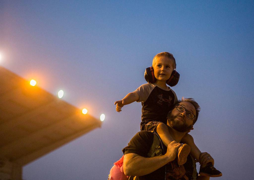 David Krenzer holds his son Logan Krenzer, 3, on his shoulders as they watch monster trucks at the Evergreen State Fair on Aug. 24, 2018 in Monroe, Wa. (Olivia Vanni / The Herald)