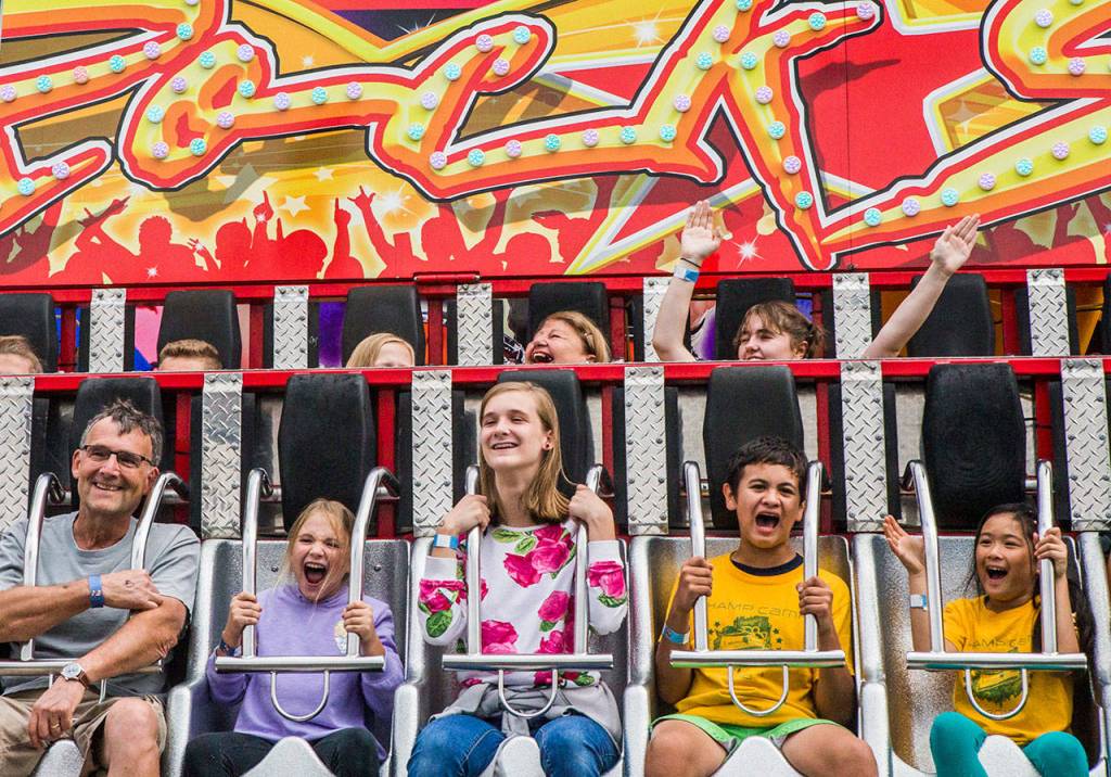 People scream as they swing upwards on the Rock Star ride at the Evergreen State Fair on Aug. 23, 2018 in Monroe, Wa. (Olivia Vanni / The Herald)